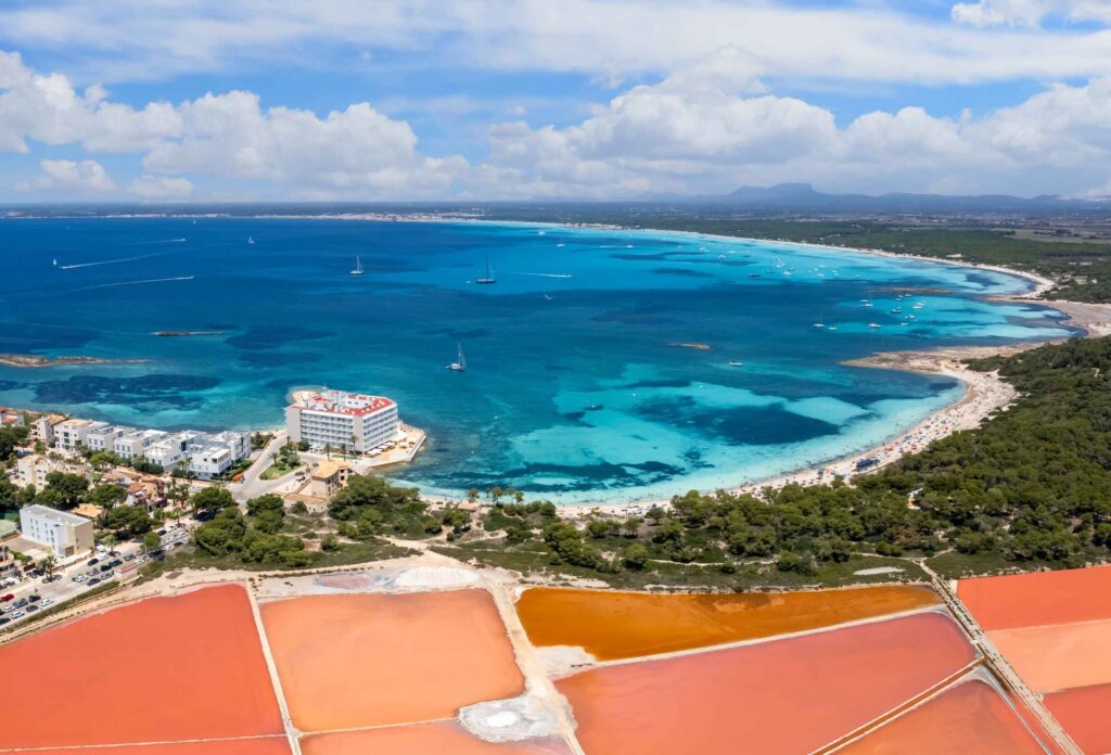Salinas de Es Trenc en Campos con sus balsas de sal y el mar turquesa de Mallorca al fondo.