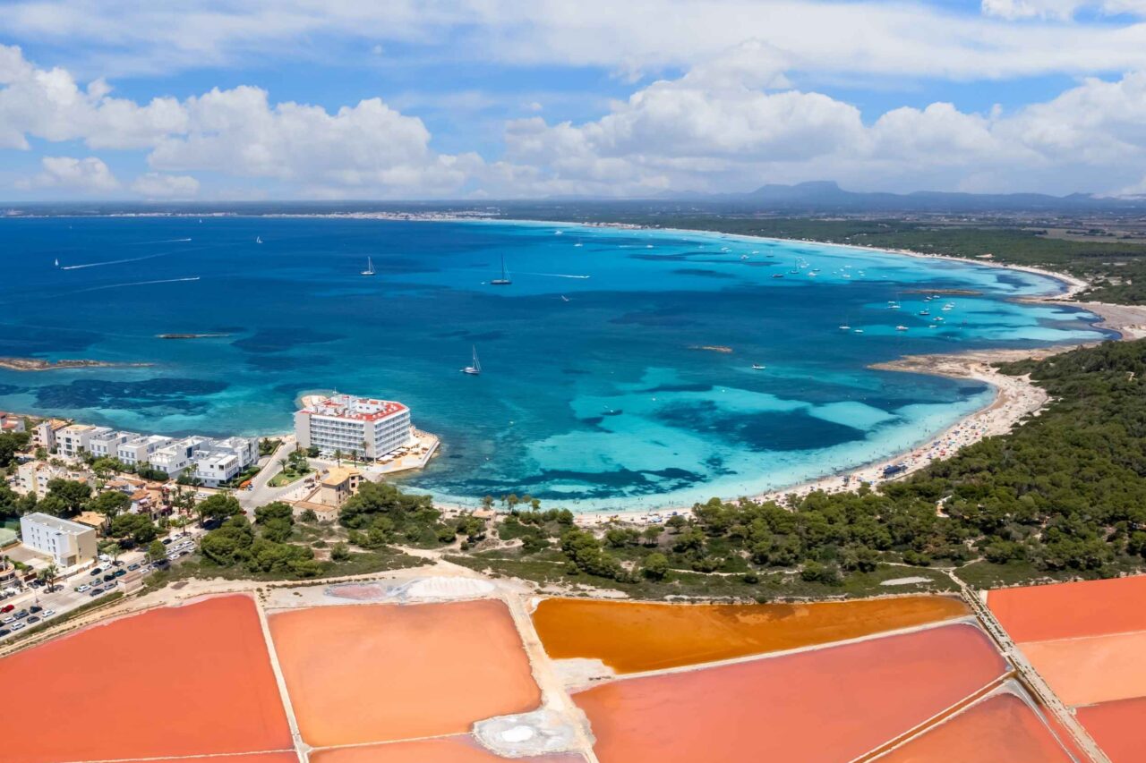 Salinas de Es Trenc en Campos con sus balsas de sal y el mar turquesa de Mallorca al fondo.